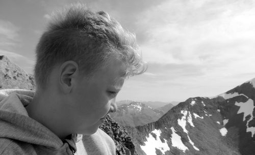 Close-up of boy against mountains and sky