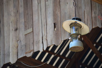 Close-up of electric lamp hanging against wall