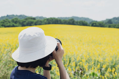  woman wearing hat photographing against sky