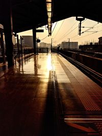 Train at railroad station platform during sunset