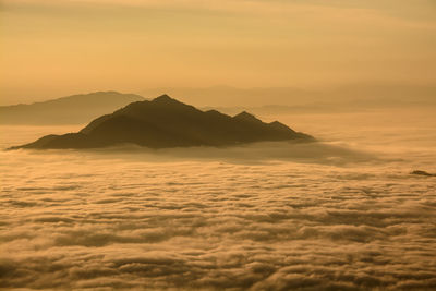 Scenic view of sea and mountains against dramatic sky