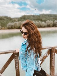 Beautiful woman standing by railing in water