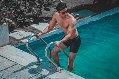 Full length of man exercising in swimming pool