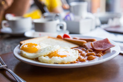 Close-up of english breakfast served in plate on table at restaurant