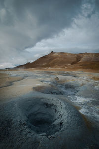 Scenic view of volcanic landscape against cloudy sky