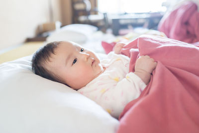 Close-up portrait of cute baby lying on bed