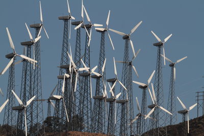 Low angle view of windmills against sky