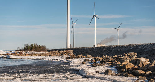 Wind turbines by the swedish baltic sea and a stone pier that protects the sea from land