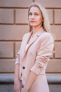 Portrait of woman standing against wall