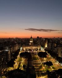 High angle view of illuminated city buildings at sunset