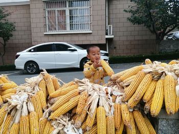 Side view of woman holding corn