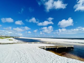 Scenic view of beach against blue sky