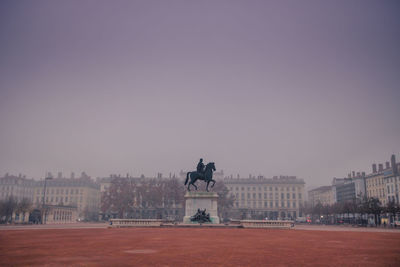 Statue and bellecour square in city against clear sky at the morning