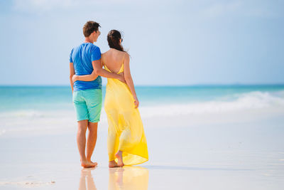 Rear view of couple standing on beach