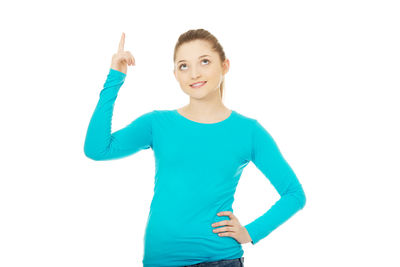 Portrait of smiling young woman standing against white background