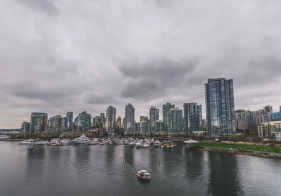 Scenic view of river by buildings against sky