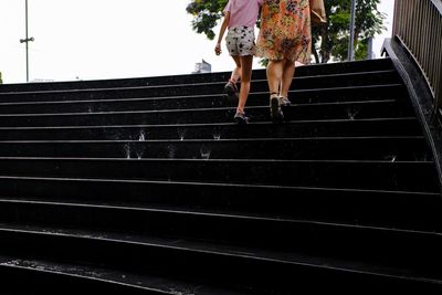 Low section of woman walking on staircase