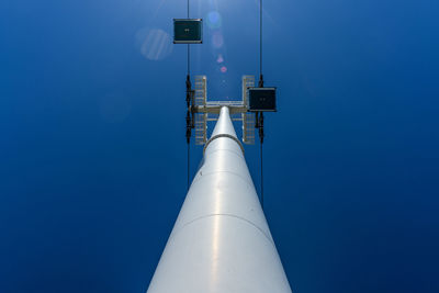Low angle view of communications tower against blue sky
