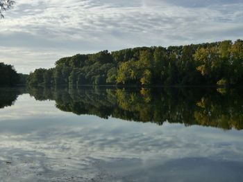 Scenic view of lake by trees against sky