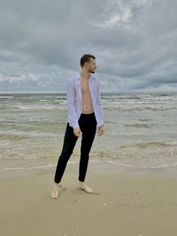 Full length of man standing on beach against sky