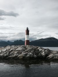 Lighthouse by sea against sky