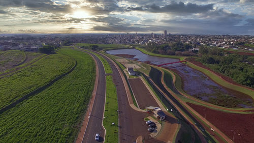 High angle view of road amidst field against sky