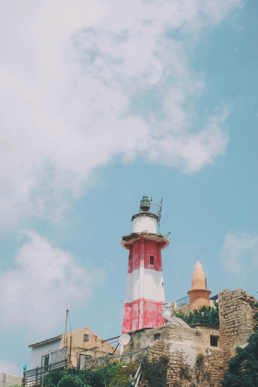 LOW ANGLE VIEW OF LIGHTHOUSE AGAINST BUILDINGS
