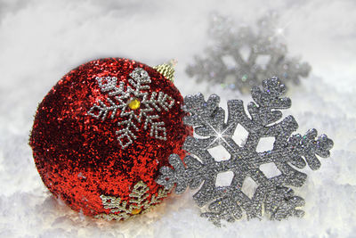 Close-up of christmas ornaments in snow