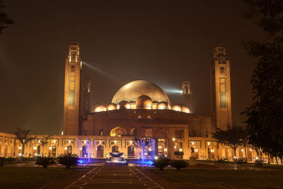 Illuminated architecture of grand mosque bahria town against sky at night