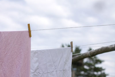 Low angle view of clothes hanging on clothesline against sky