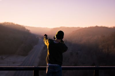 Man on mountain road during sunset