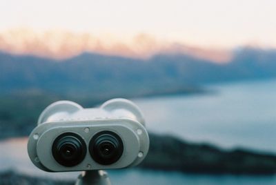 Close-up of coin-operated binoculars against sky