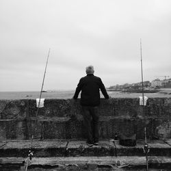 Rear view of man standing against sky