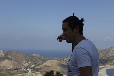 Man looking at mountain against sky