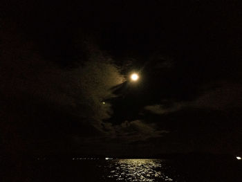 Illuminated sea against sky at night