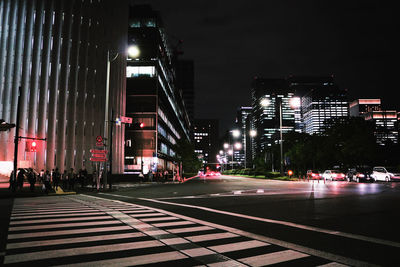 Illuminated city street and buildings at night