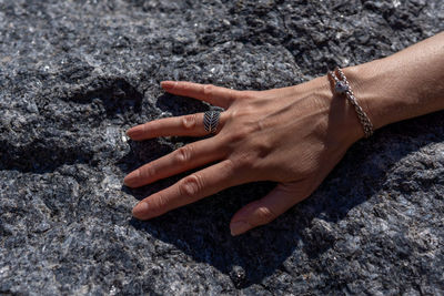 High angle view of woman hand on rock