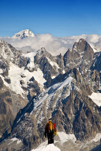 Rear view of person on snowcapped mountains against sky