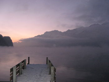 View of jetty on calm sea at sunset