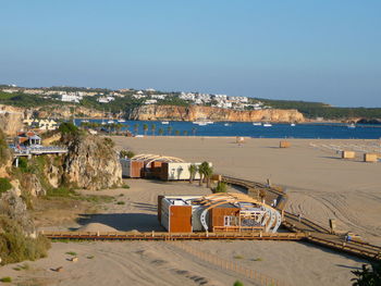 Scenic view of beach by buildings against clear sky