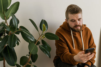 Portrait of young man holding plant
