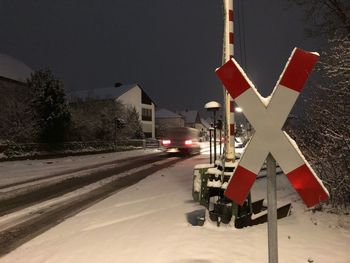 Road sign on street against sky during winter