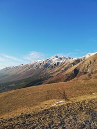 Scenic view of landscape and mountains against blue sky