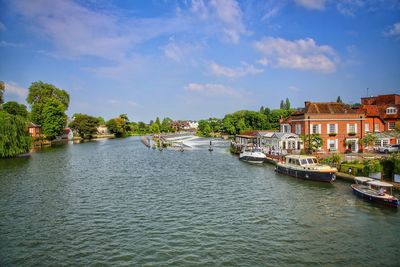 View of buildings at waterfront against cloudy sky
