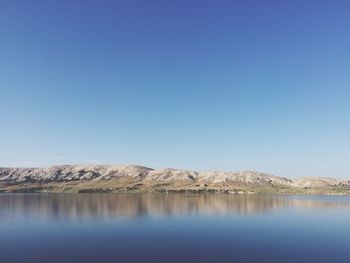 Scenic view of lake against clear blue sky