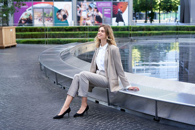 Portrait of young woman sitting on street