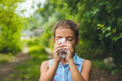 Front view of girl drinking water from glass