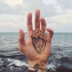 Cropped image of hand holding sea