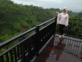 Portrait of smiling woman in hijab standing at observation point