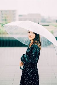 Young woman standing on wet glass during rainy season